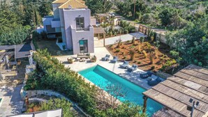 Une villa moderne dotée d’une piscine, d’un espace salon extérieur et d’un jardin.