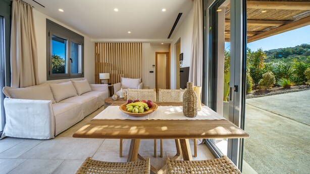 Un salon moderne avec un canapé, une table à manger et une vue sur l’extérieur.