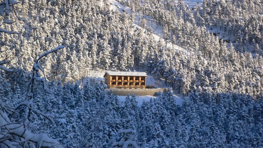 A wooden lodge surrounded by snow-covered trees.