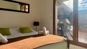 Une chambre d’hôtel avec un lit, une fenêtre, un miroir et une vue sur l’extérieur.