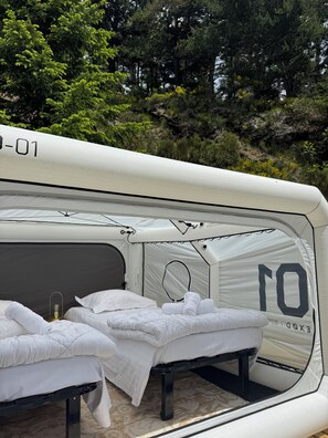 A tent with two beds, a small table, and a lamp. - ADRECHAS MERCANTOUR (Valdeblore)