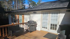 A covered deck with a grill, outdoor seating, and a door leading to a garage. - Close 2 Masters Newly Renovated  3-bedroom 2.5 bath home in lovely North Augusta (North Augusta)
