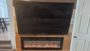 A modern living room with a large flat-screen TV mounted above a fireplace. - Close 2 Masters Newly Renovated  3-bedroom 2.5 bath home in lovely North Augusta (North Augusta)