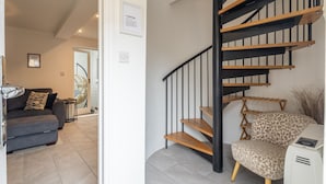 Ein modernes Interieur mit einer Treppe, einem Sofa und einem Sessel.