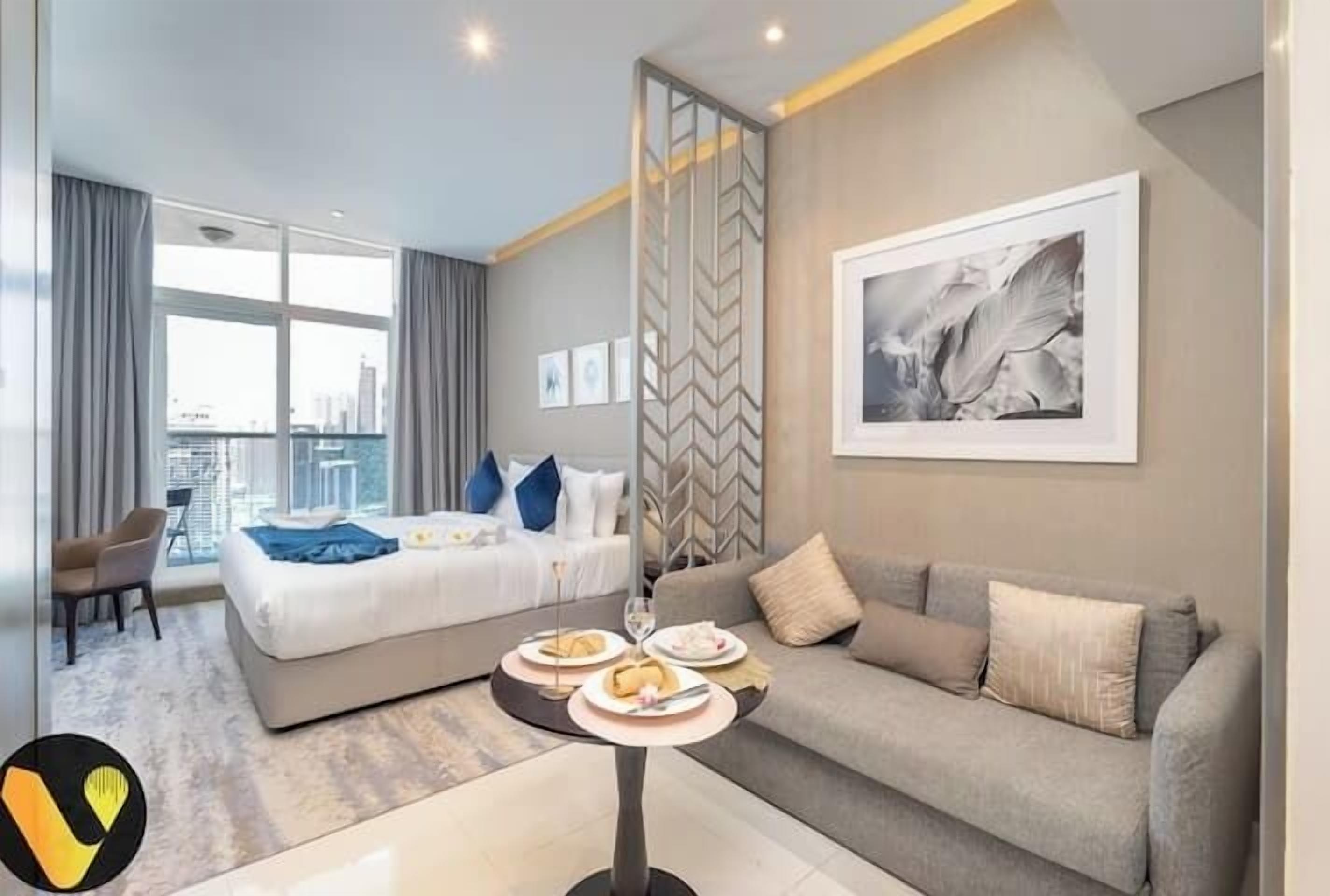 Een moderne hotelkamer met een bed, een zithoek, een eettafel en uitzicht op de stad.