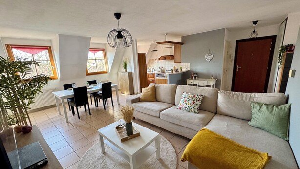 A modern living room with a sofa, coffee table, and dining area. - Spacious, quiet apartment in the heart of Rouffach (Rouffach)
