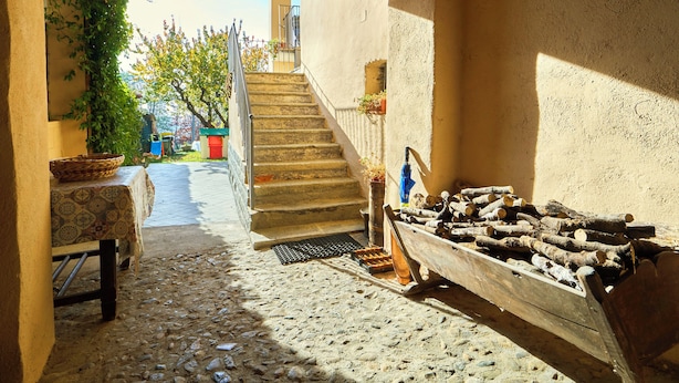 A stone staircase leading to a higher level, a rustic wooden bench, a wicker basket, and a pile of firewood. - CASA PATRON-Large Italian Alps Holiday Home Italy- 1h from Turin- Pet friendly (Pecco)