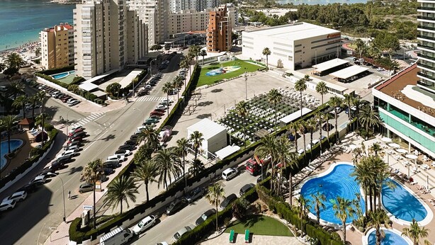 Un hotel con piscina, estacionamiento y vistas a la ciudad y al mar.