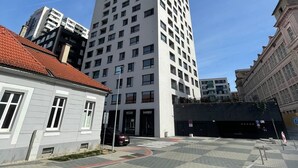 Un immeuble moderne et imposant, doté d’une façade blanche et de nombreuses fenêtres.