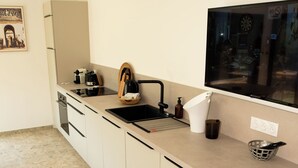 A modern kitchen with a large island, a built-in oven, and a sink. - VILLA NEPITA Modern 1-bedroom with private pool (Porto-Vecchio)