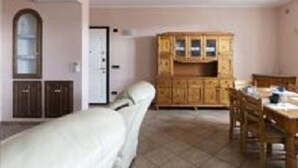 Ein Zimmer mit einem Bett, einem Holzschrank, einem Esstisch und einem Stuhl.