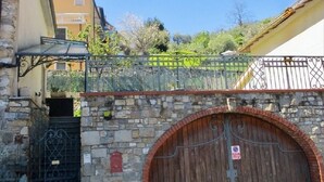 Eine Steinmauer mit einem hölzernen Tor und einem Metallzaun.