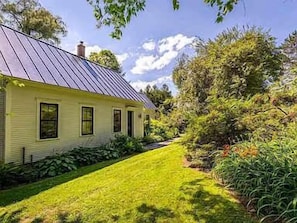 Una casa amarilla con techo inclinado y paneles solares.