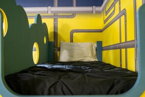 Ein Stockbett in Grün-Gelb, mit einem runden Fenster an der linken Seite.