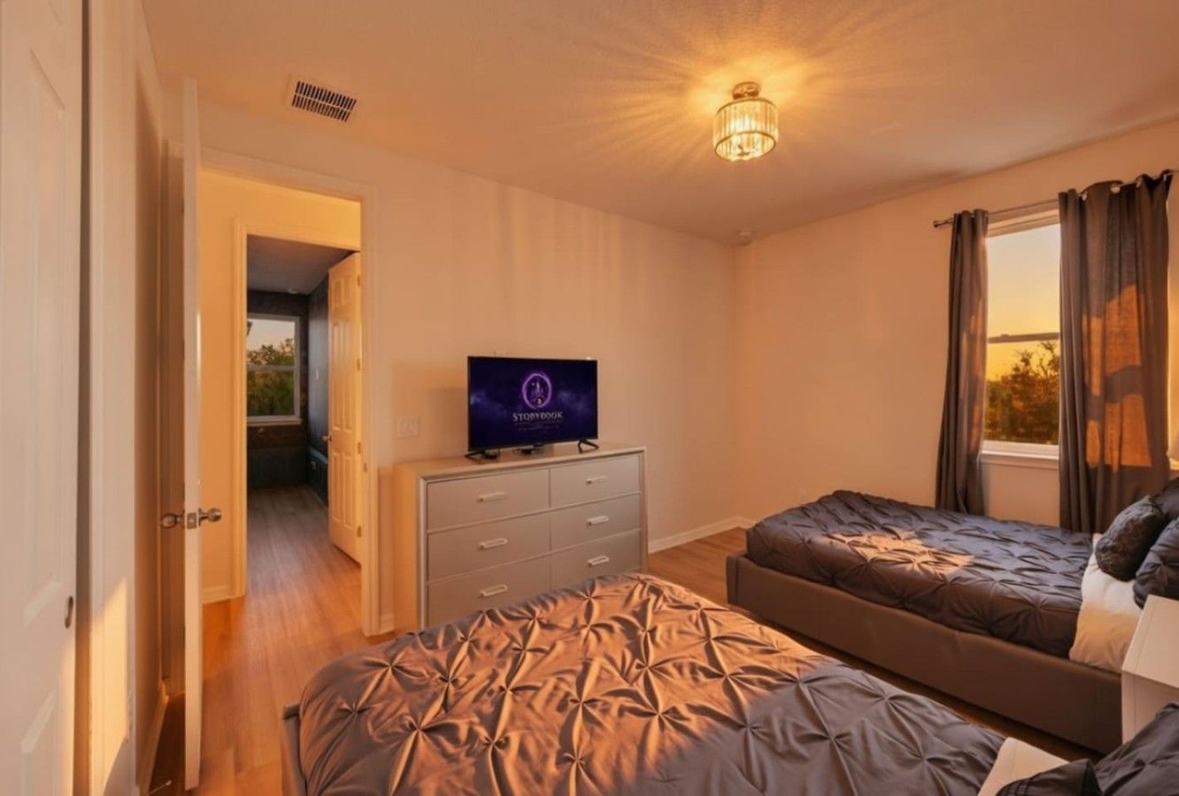 Ein Schlafzimmer mit zwei Betten, einem Fernseher, einem Schminktisch und einem Fenster mit Vorhängen.