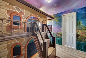Ein Zimmer mit Treppe, einer Tür und einem Wandgemälde.