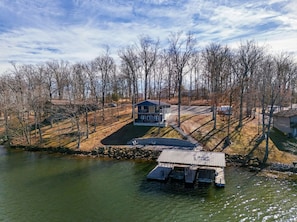 A lakeside property with a dock, a house, and a boat. - Blue Blessing, Hot tub, Waterfront, bunk room (Goreville)