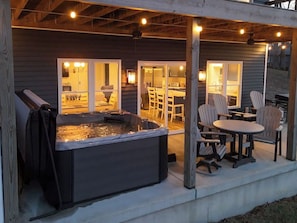 A hot tub with seating and tables on a covered patio. - Blue Blessing, Hot tub, Waterfront, bunk room (Goreville)