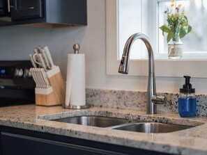 A kitchen with a double sink, a knife block, a paper towel holder, and a soap dispenser. - Blue Blessing, Hot tub, Waterfront, bunk room (Goreville)