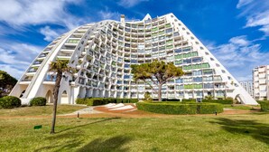 Ein modernes Hotel mit einzigartiger, geschwungener Architektur, mehreren Balkonen und einem gepflegten Garten.