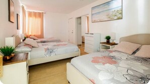 Un dormitorio con dos camas, un escritorio y una silla.