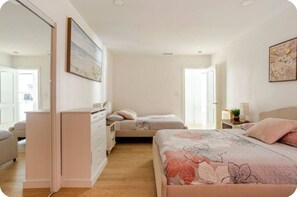 Une chambre à coucher avec un lit, une commode, une table de chevet et un tableau au mur.