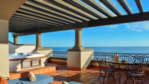 A terrace with a grill, seating, and a table with drinks, overlooking the sea. - GORGEOUS 3-bedroom villa in Cabo San Lucas - infinity pool (Cabo San Lucas)