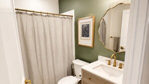 A bathroom with a toilet, sink, and shower curtain.
