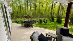 An outdoor patio area with wicker furniture, a table, and chairs.