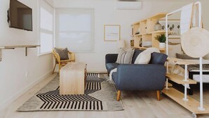 Una sala de estar moderna con un sofá, una mesa de centro y una estantería.
