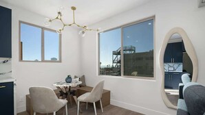 A modern room with a dining area, two chairs, a table, and a large mirror. - Refined Retreat in Banker's Hill (San Diego)