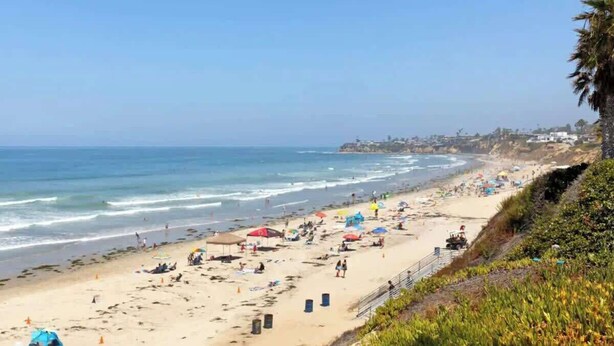 A beach with umbrellas, people, and a clear sky. - Steps Away from PB Beaches + Hot Tub (San Diego)
