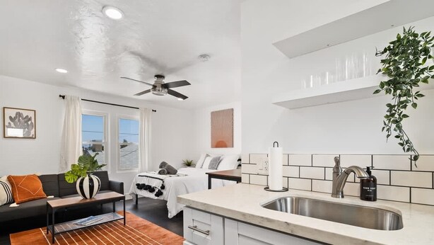 A modern kitchen with a built-in sink, white cabinets, and a ceiling fan. - Perfect Studio in the Best Location of North Park! (San Diego)
