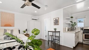 A modern apartment with a kitchen, dining area, and a living room with a large bed. - Perfect Studio in the Best Location of North Park! (San Diego)