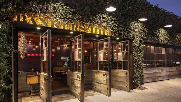 Un restaurant à l’aspect rustique, avec une grande porte en bois et une enseigne au-dessus de l’entrée.