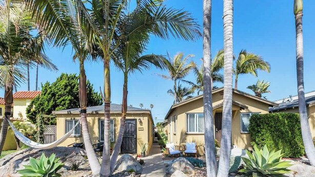 A residential area with palm trees, a hammock, and a pathway leading to houses. - Quiet, Comfortable Sunset Cliffs Ocean Beach Apartment – Walk to Beach! (San Diego)