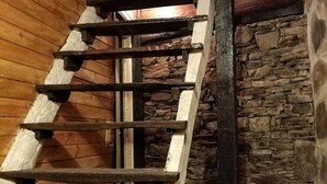 Een houten trap met een stenen muur aan de zijkant.