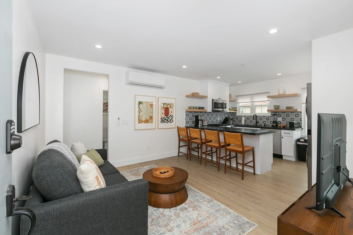 A modern apartment with a living room, kitchen, and dining area.