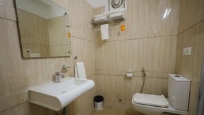 A bathroom with a sink, mirror, toilet, and towel rack. - Hotel East Gate By Vablis Hospitality (Agra)