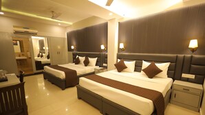 A hotel room with two beds, a desk, a chair, a nightstand, and a mirror. - Hotel East Gate By Vablis Hospitality (Agra)