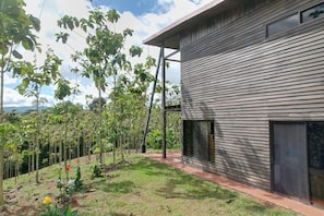 A modern building with horizontal siding and large windows. - Charming Private Retreat in the Rainforest near Jaco (San Gabriel)