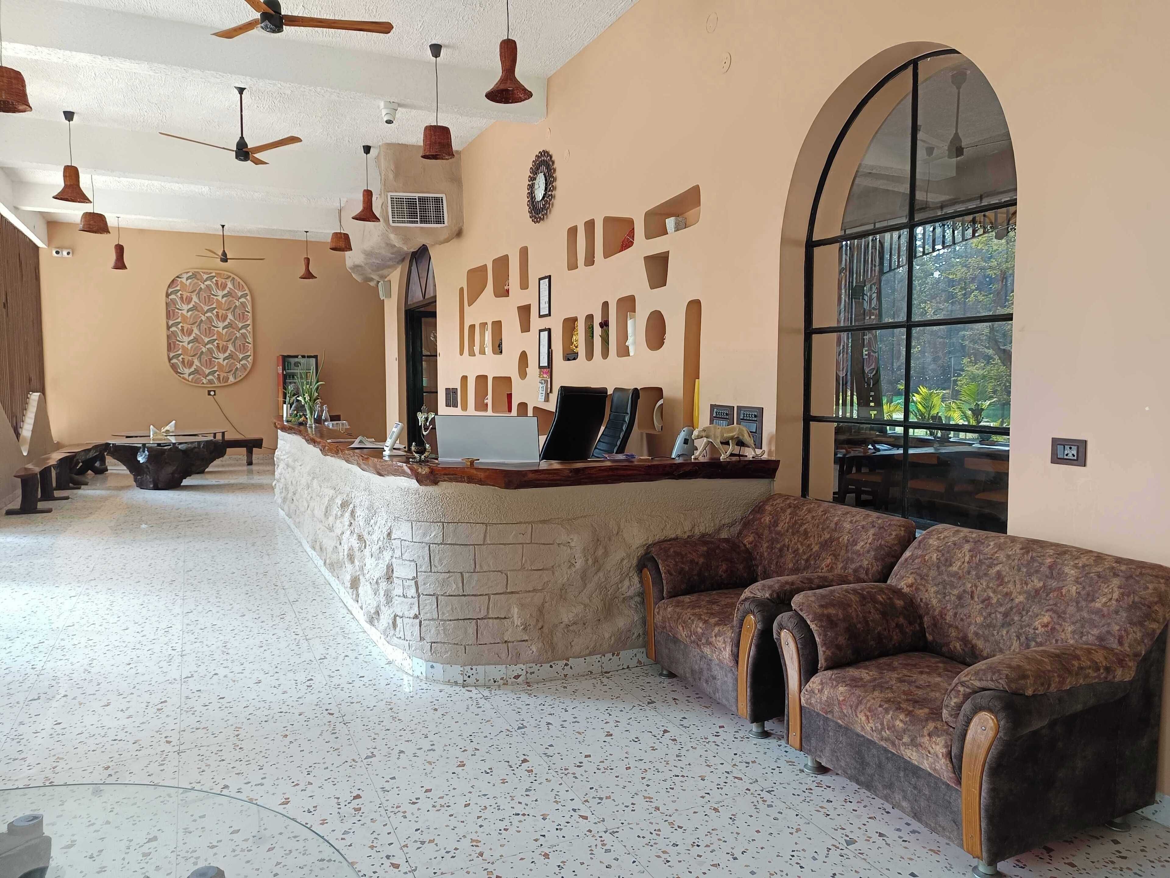 A spacious lobby with a reception desk, a sofa, and a pool table.