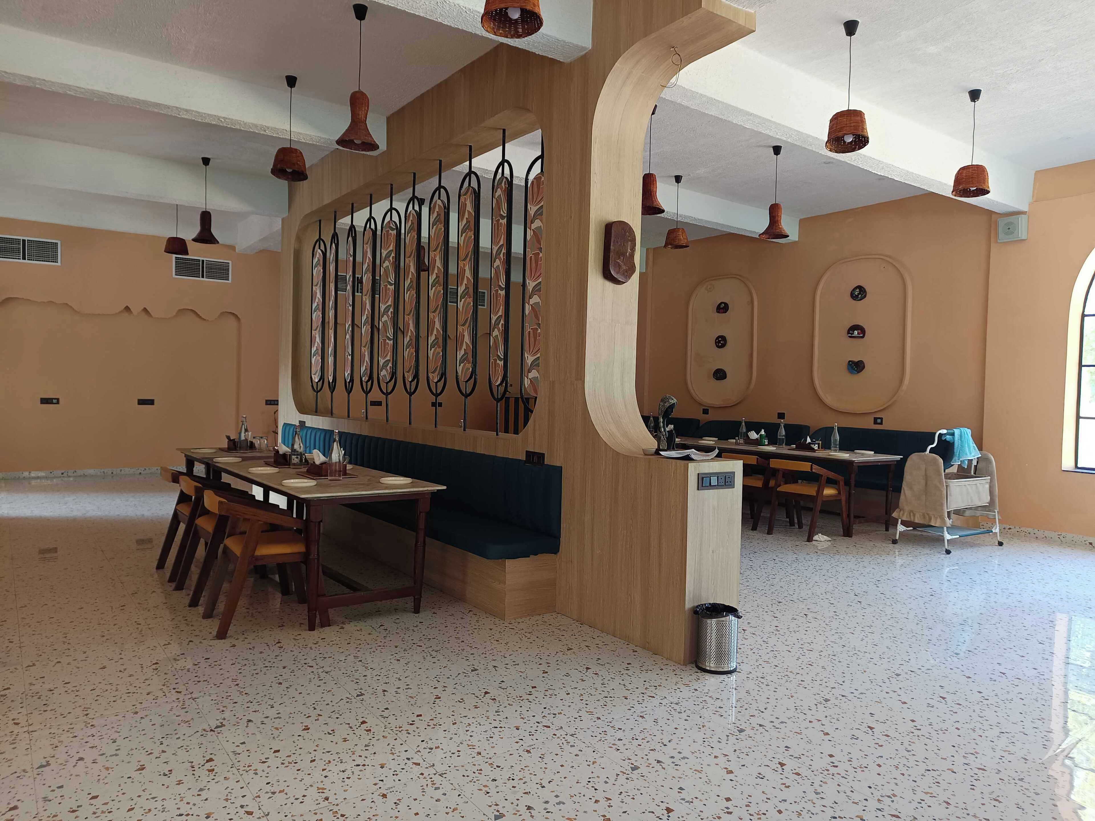 A spacious dining area with a long wooden table and chairs, a decorative wall with vertical elements, and a large window providing natural light.