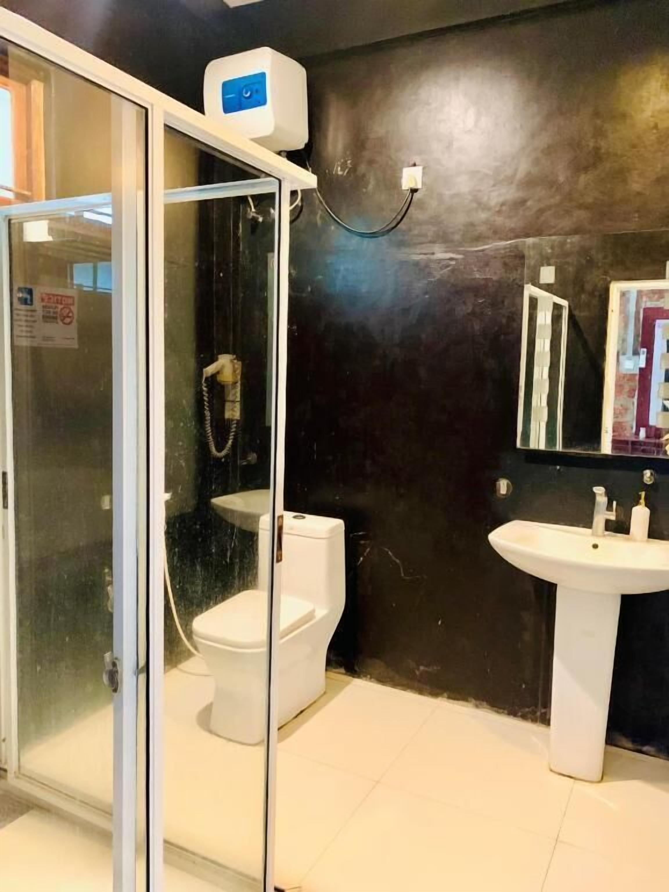 A bathroom with a glass-enclosed shower, a white toilet, and a pedestal sink.