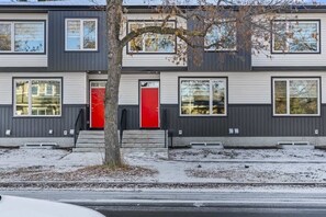A modern two-story building with a red door and windows. - Stylish 3BR Townhouse Near U of A (Edmonton)