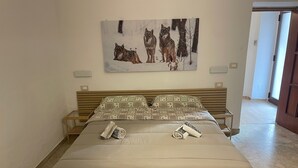 Ein Bett mit Holzbettgestell, einer gesteppten Decke und zwei gerollten Handtüchern.