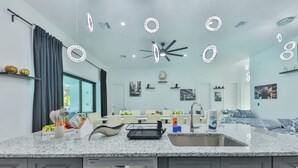 A modern kitchen with granite countertops, a dishwasher, and a dining area with a table and chairs.