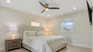 A bedroom with a bed, nightstands, lamps, a ceiling fan, and two windows. - Cozy Home in Newton (Newton)