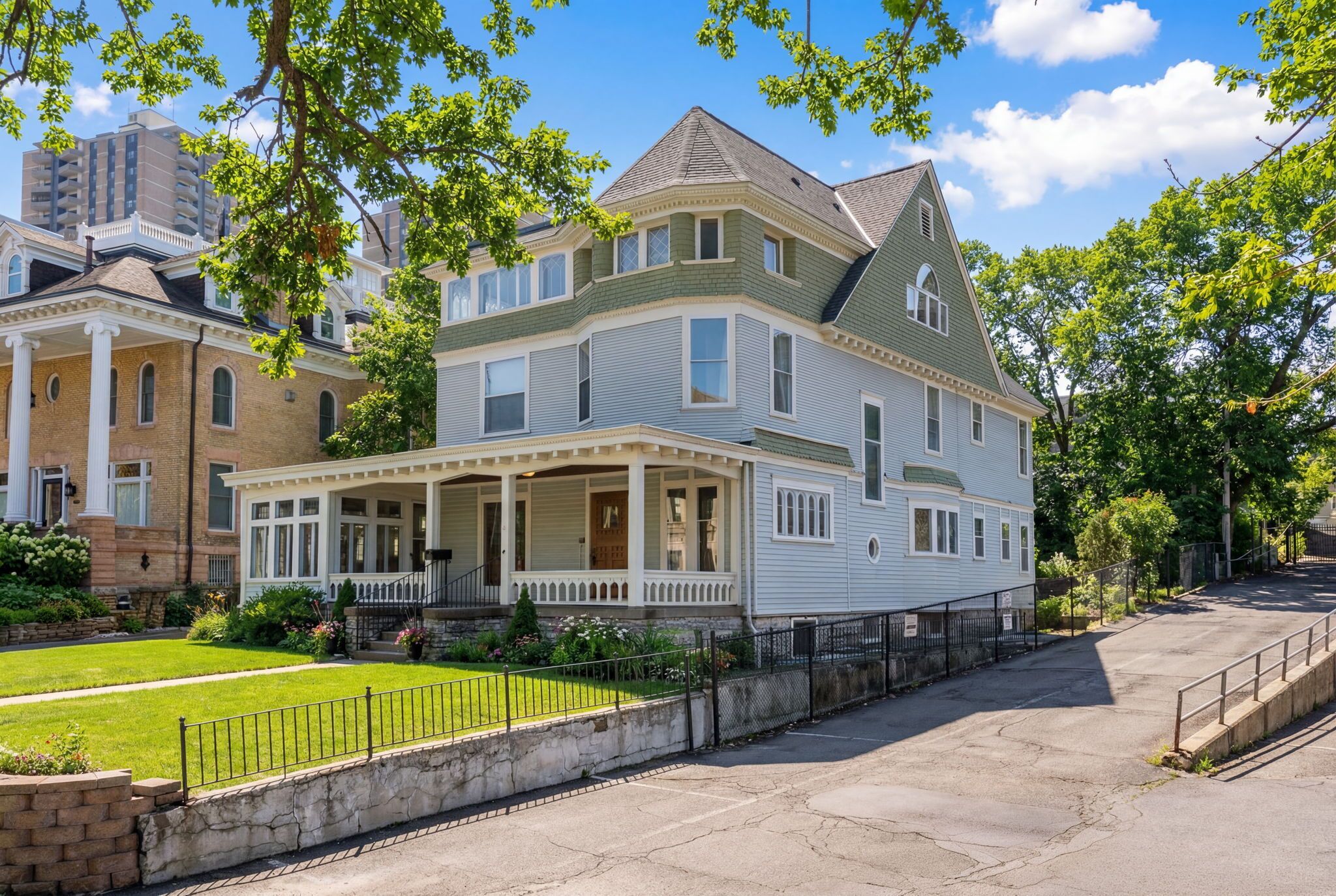 A large, two-story house with a wrap-around porch and a stone foundation.