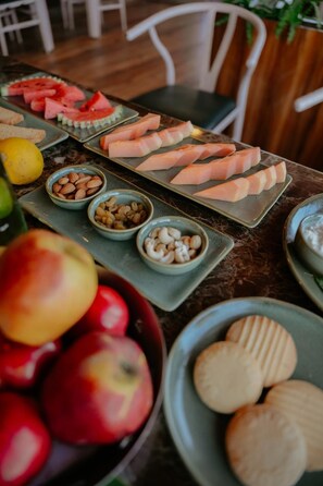 A table with various food items including watermelon, almonds, and cookies. - Aryans Sea Sight Resort Mandarmani (Kanthi)